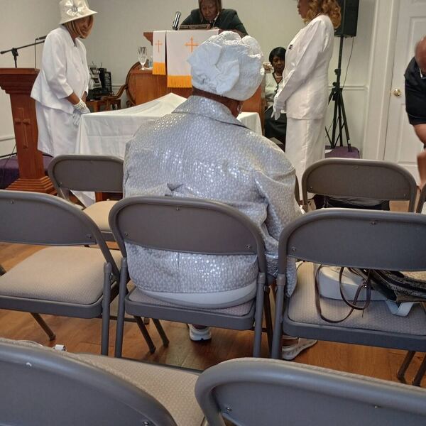 Women in white robes standing at the altar